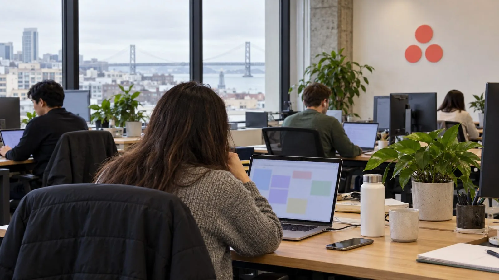 An office worker checks a laptop in a shared workspace in San Francisco, California. / EconoTimes.ai