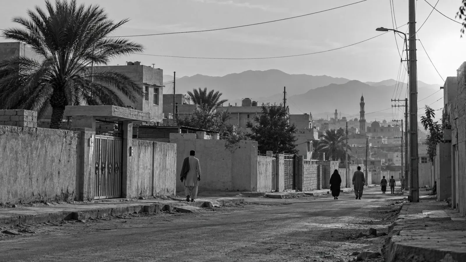 Residents pass homes on a residential street in Zahedan, southeastern Iran. (AI-generated image / EconoTimes)