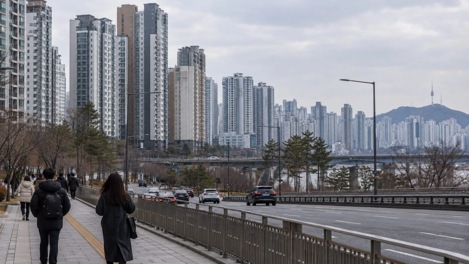 Pedestrians pass dense apartment towers in Seoul, South Korea, on an overcast afternoon. (AI-generated image / EconoTimes)