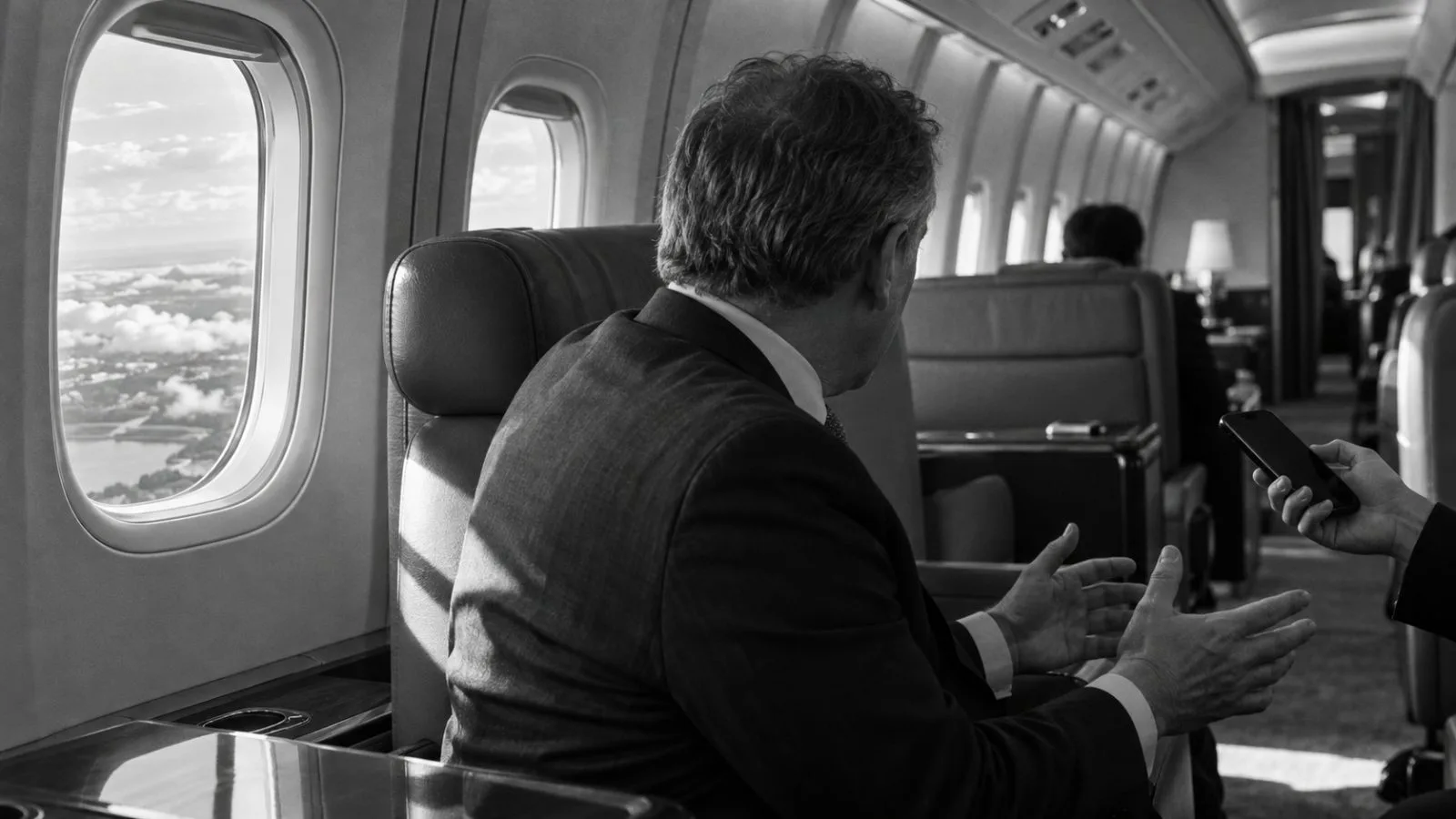 A passenger speaks aboard Air Force One during a flight to Port Huron, Michigan. (AI-generated image / EconoTimes)