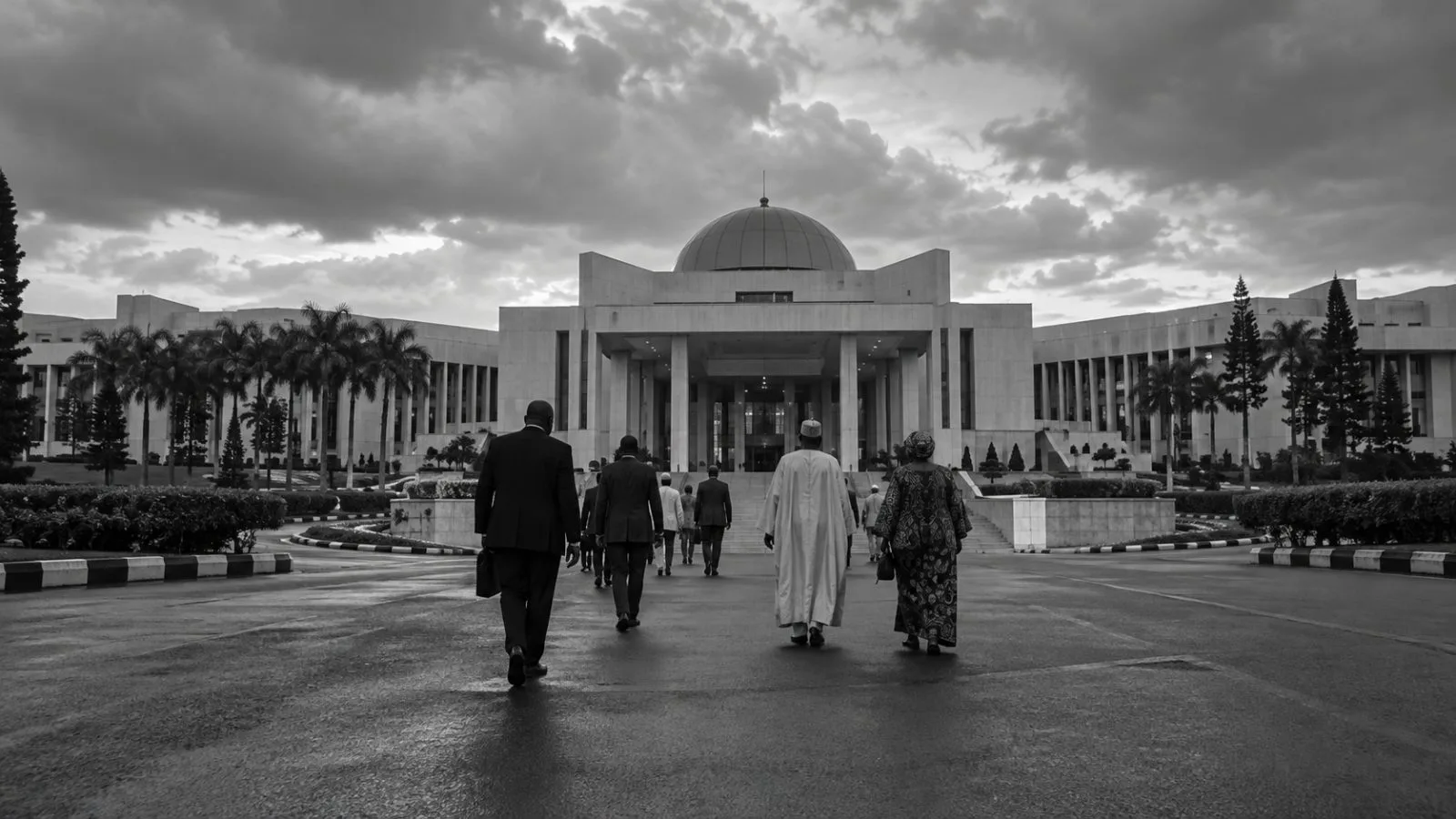Visitors walk toward Nigeria’s State House in Abuja beneath overcast afternoon light. (AI-generated image / EconoTimes)