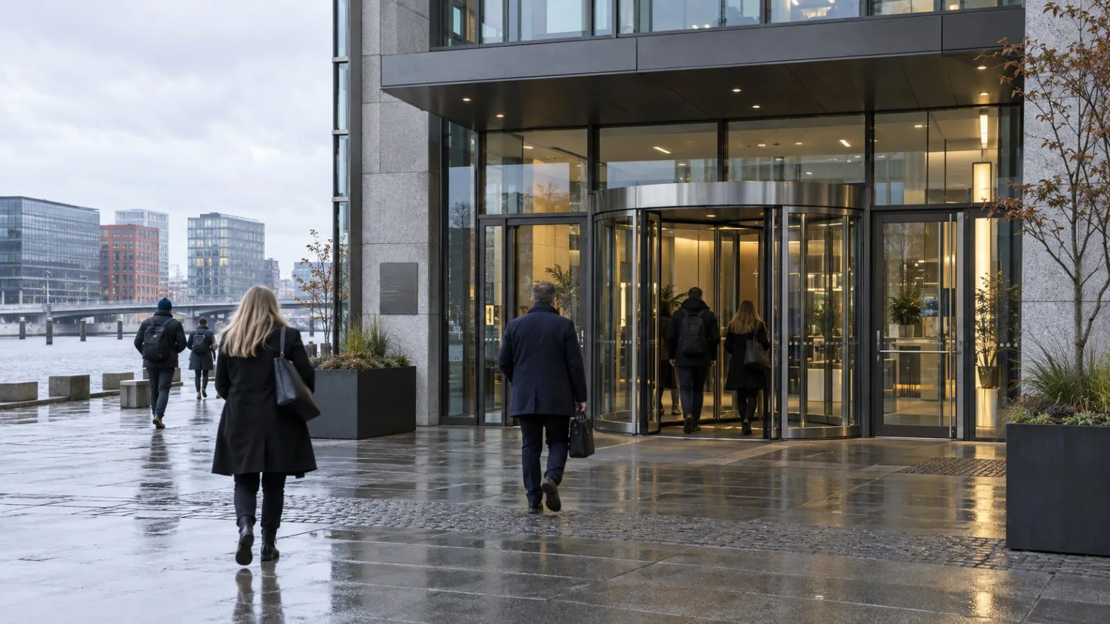Commuters pass the Glaskuben office building on Kalvebod Brygge in Copenhagen, Denmark / EconoTimes.ai