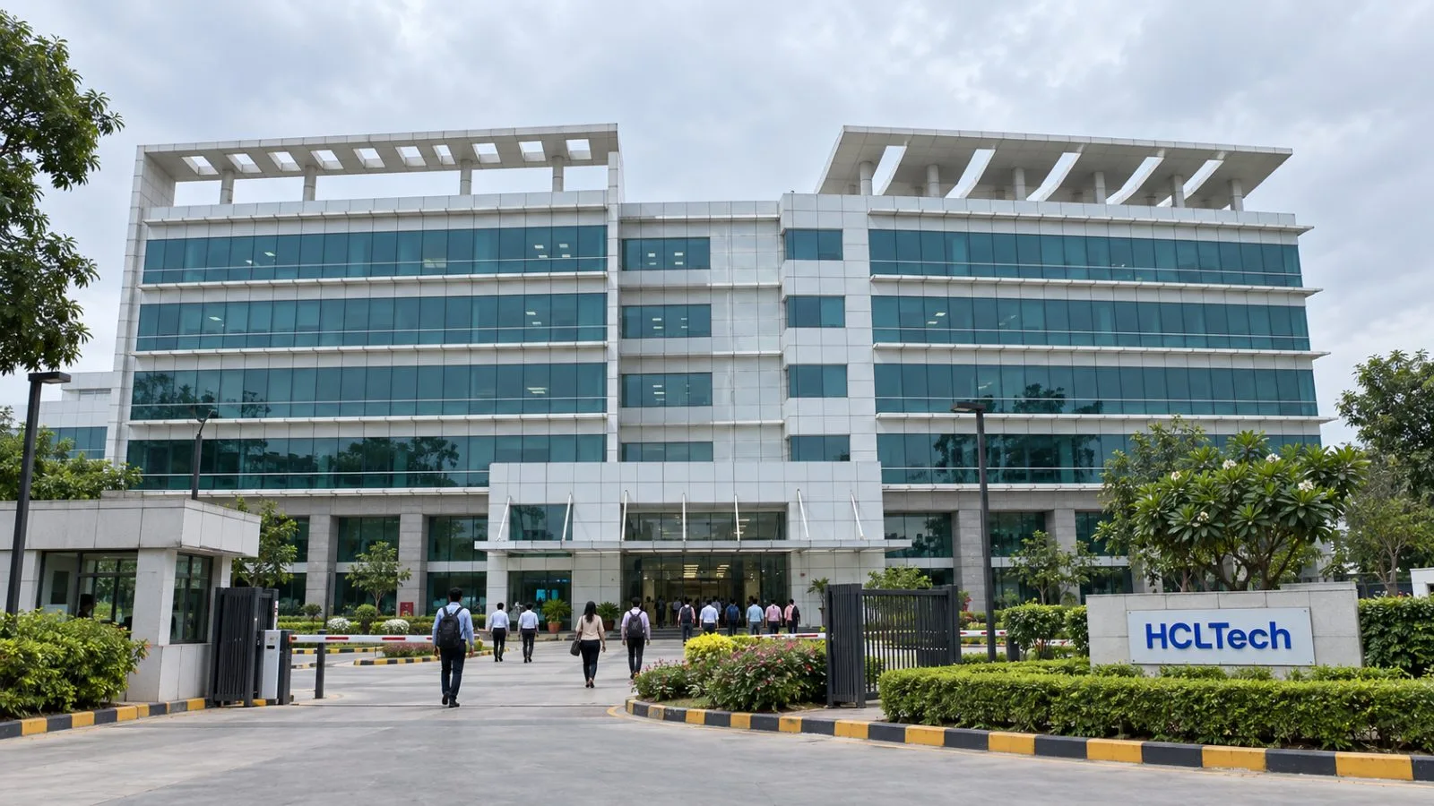Employees walk toward an office campus in Noida, India, on an overcast morning. / EconoTimes.ai