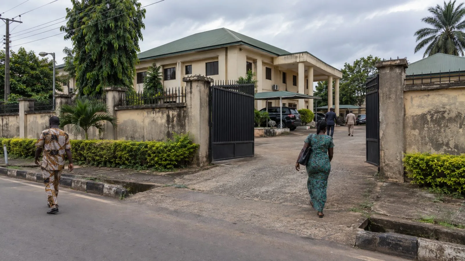 Pedestrians pass a party office in Awka, Anambra State, Nigeria. (AI-generated image / EconoTimes)