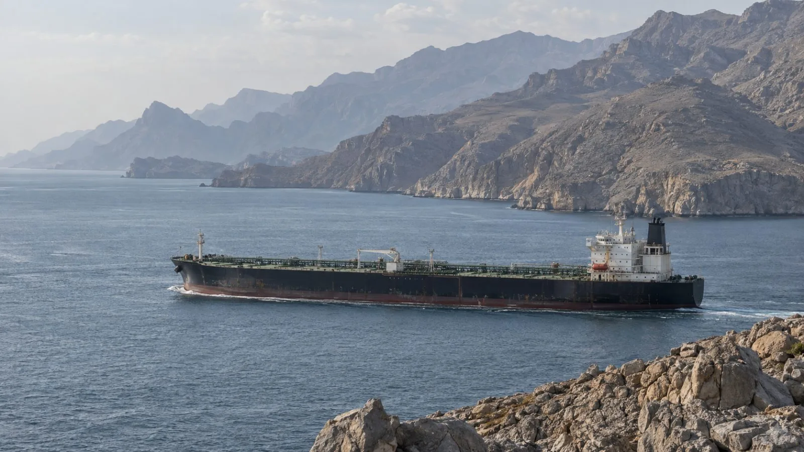An oil tanker passes through the Strait of Hormuz off Khasab, Oman. (AI-generated image / EconoTimes)