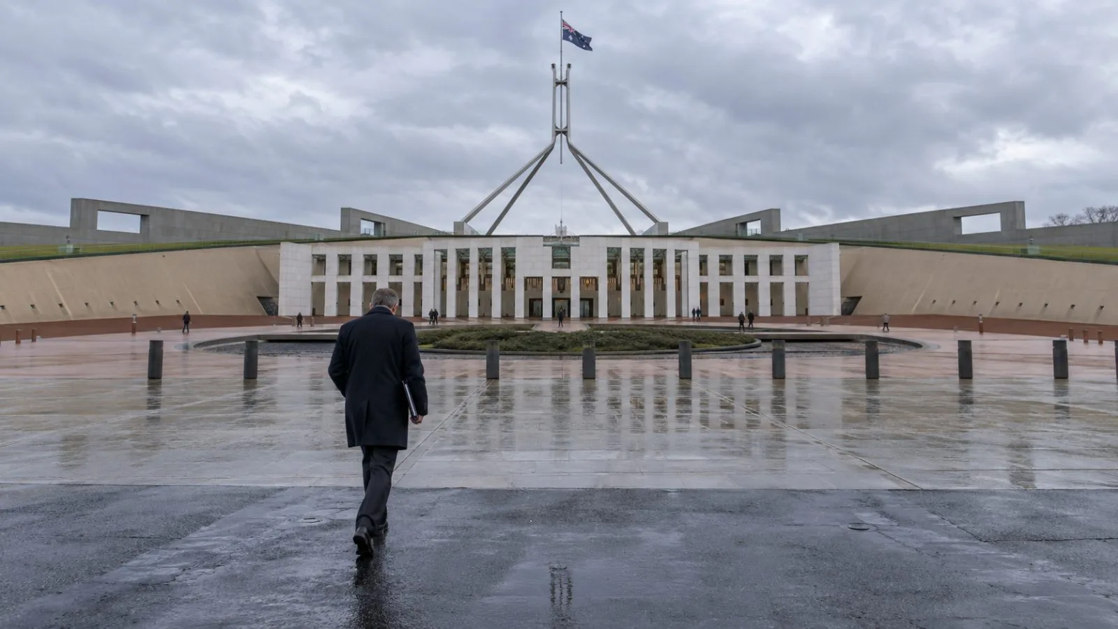 A pedestrian crosses the forecourt at Parliament House in Canberra on an overcast morning. (AI-generated image / EconoTimes)