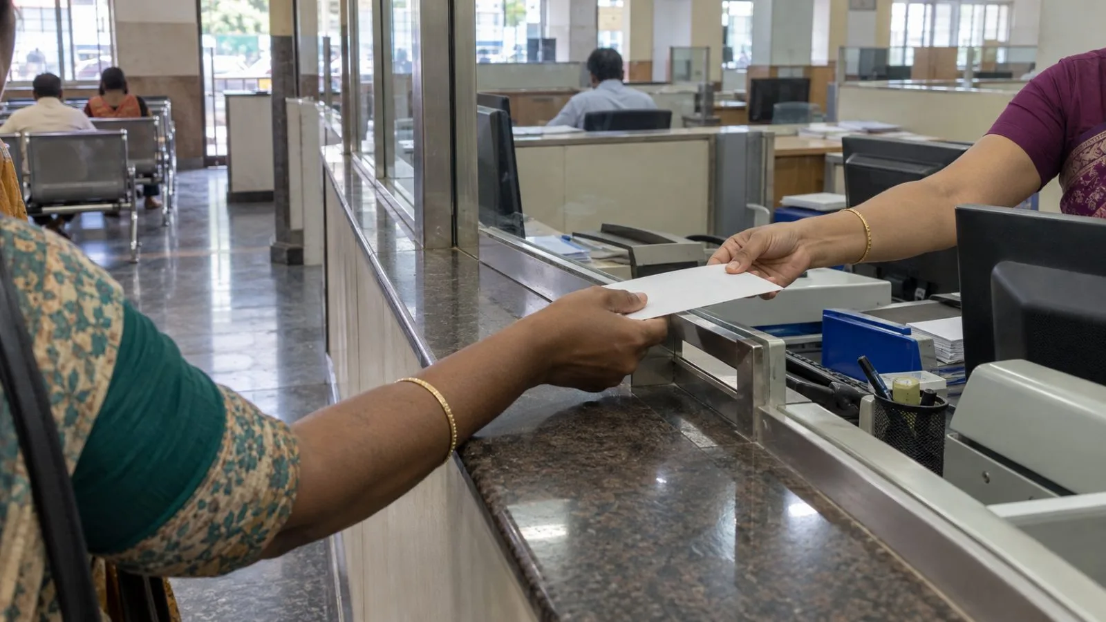 A customer receives a deposit receipt at an Indian Bank branch in Chennai, India. (AI-generated image / EconoTimes)
