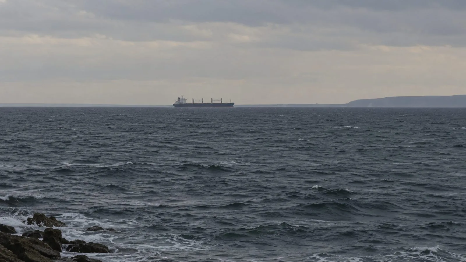 A cargo vessel crosses the Black Sea off Varna, Bulgaria, beneath low gray clouds. (AI-generated image / EconoTimes)