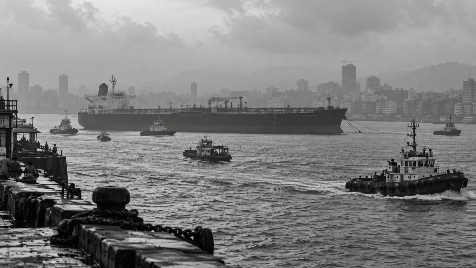 A crude oil tanker waits offshore as smaller vessels cross Mumbai harbor (AI-generated image / EconoTimes)