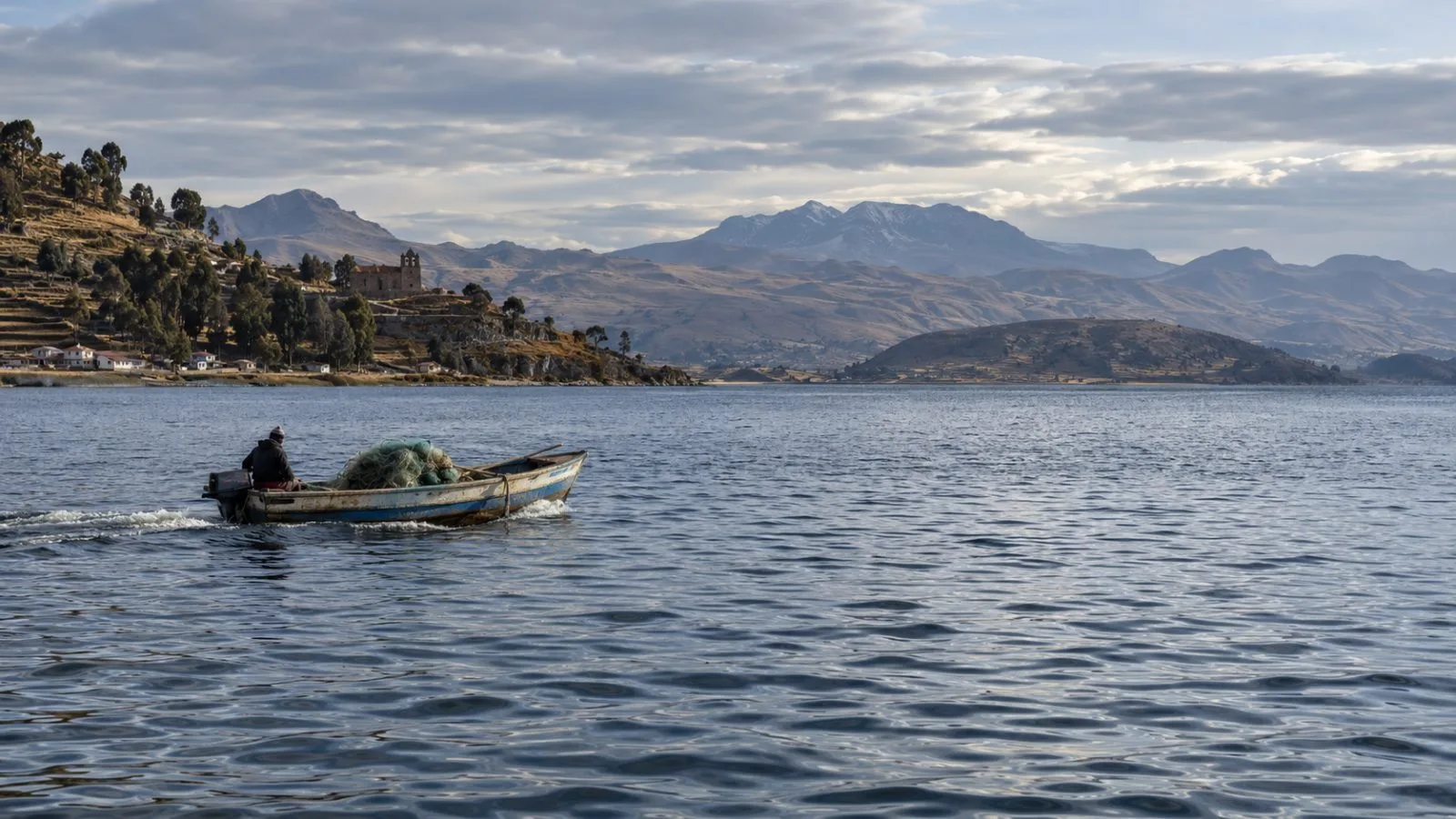 A fishing boat crosses Lake Titicaca near Chucuito, Peru, with a net piled at its stern. (AI-generated image / EconoTimes)