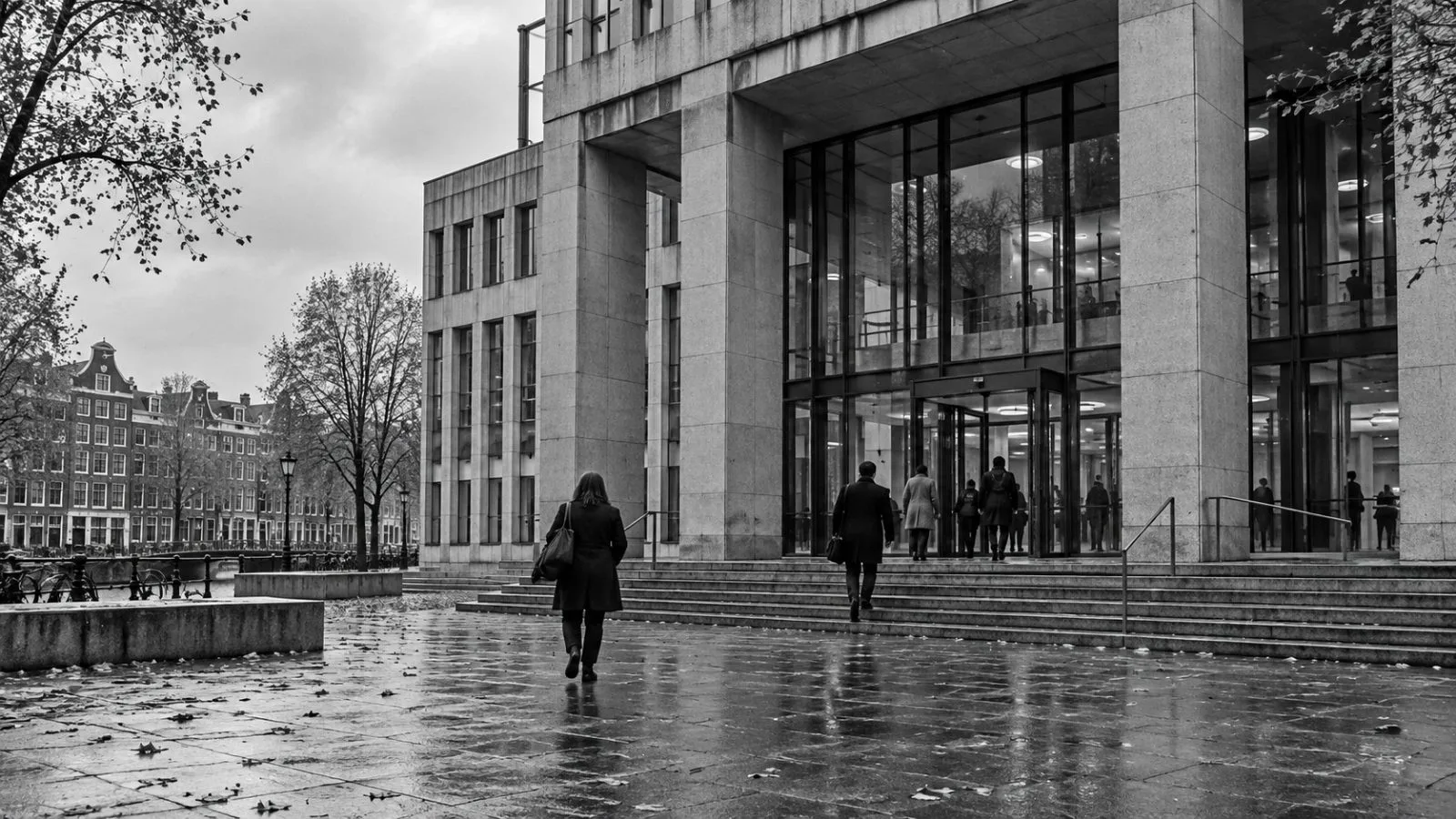 Visitors enter Amsterdam District Court in Amsterdam, Netherlands, beneath an overcast morning sky. / EconoTimes.ai