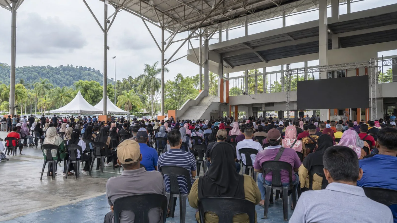 Attendees gather at Hang Jebat Sports Complex in Krubong, Melaka, for a public programme. (AI-generated image / EconoTimes)