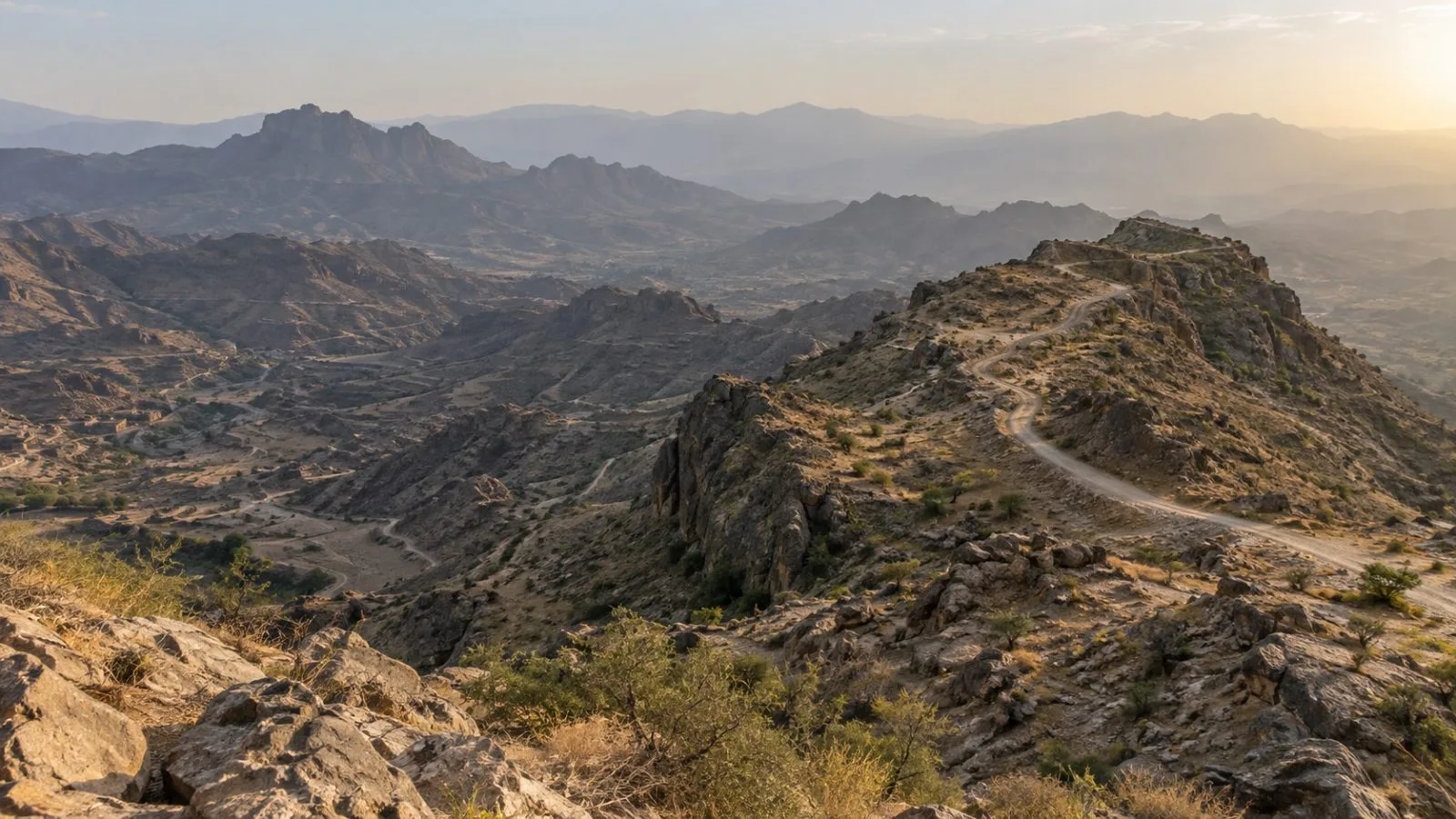 A rocky road crosses the highlands near Jabal Al-Manara in Al-Misrakh, Taiz, Yemen. (AI-generated image / EconoTimes)