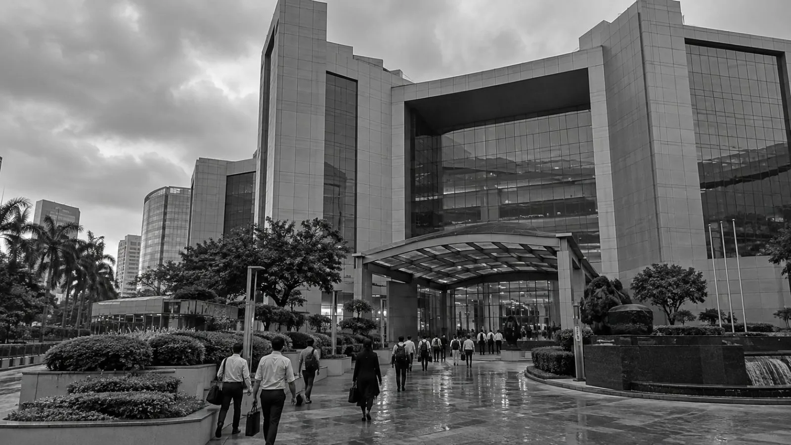 Commuters pass the National Stock Exchange building in Mumbai’s Bandra-Kurla Complex on an overcast morning. (AI-generated image / EconoTimes)