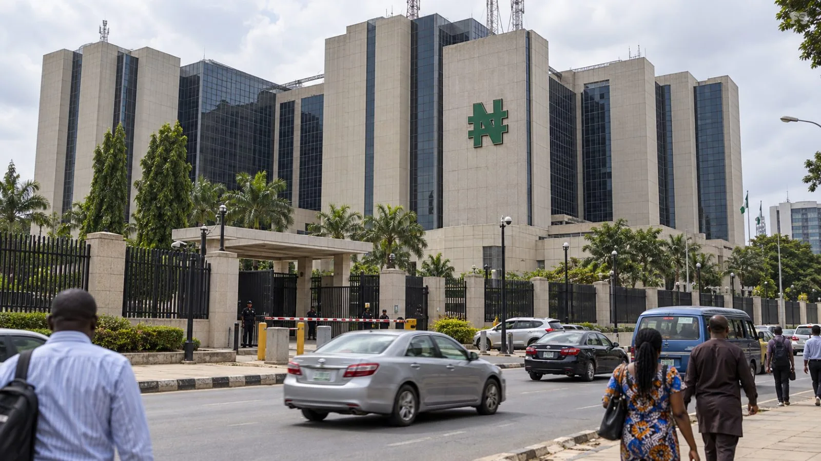 The Central Bank of Nigeria headquarters stands beside a quiet street in Abuja. / EconoTimes.ai