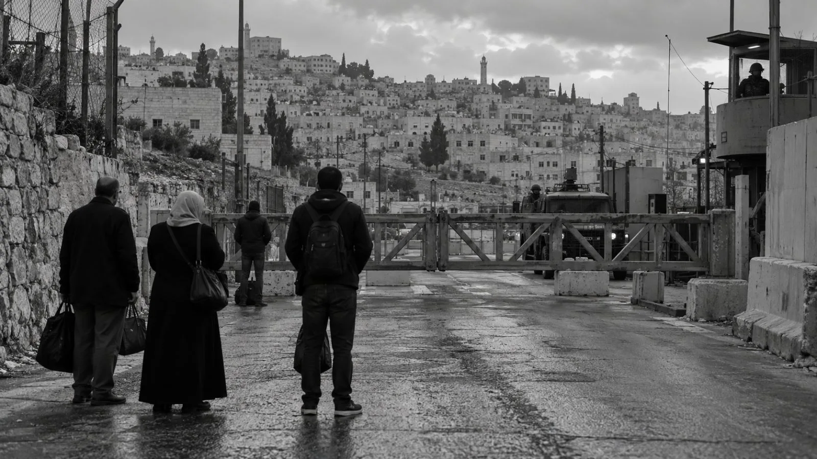 A closed road barrier blocks traffic at a checkpoint in Hebron, West Bank (AI-generated image / EconoTimes)