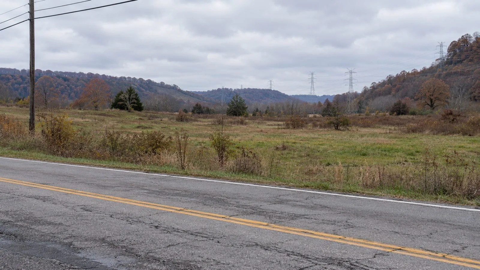 An undeveloped parcel beside Charleston Road in Buffalo, West Virginia, sits near utility lines. (AI-generated image / EconoTimes)