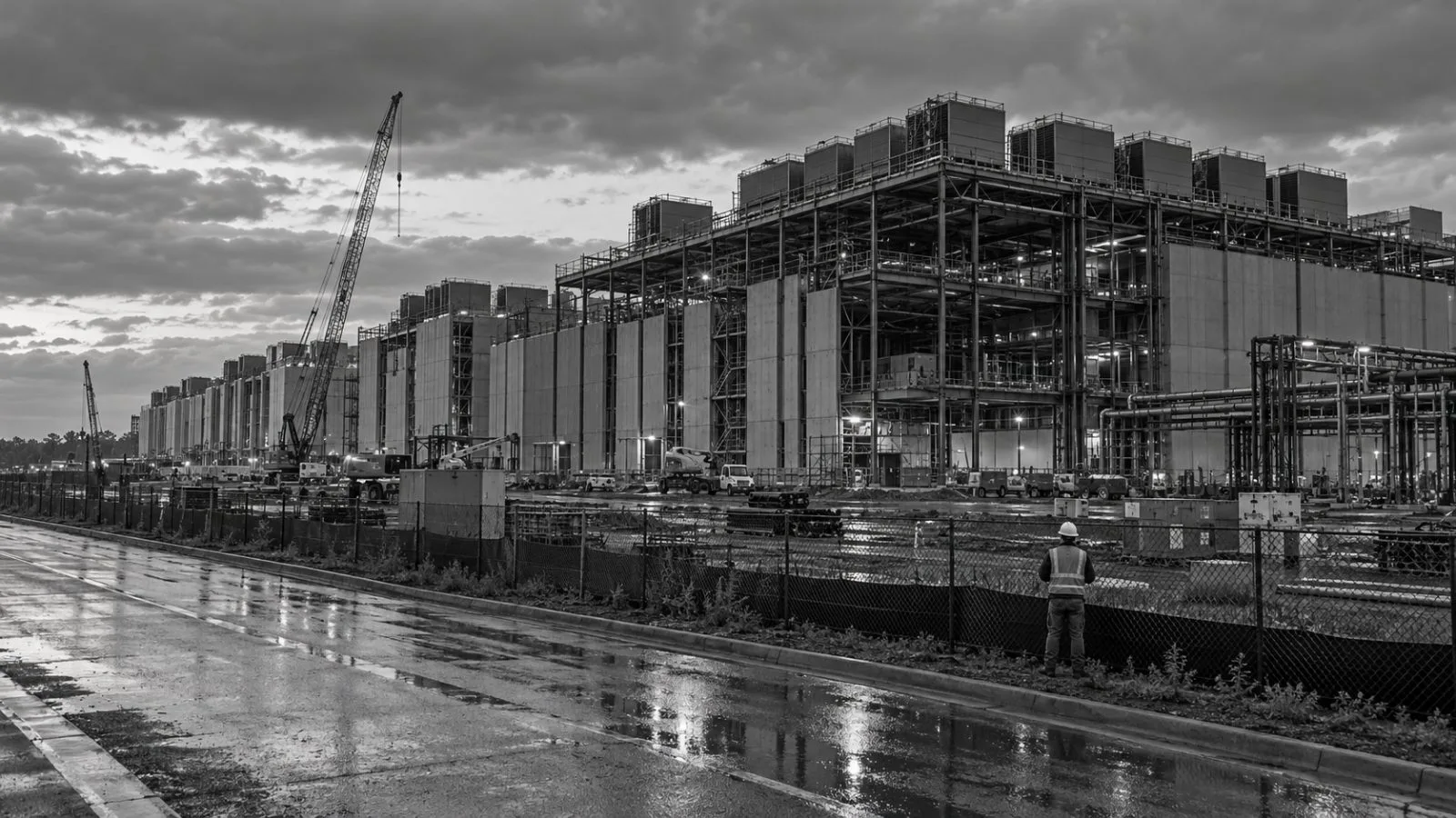 A data center under construction stands behind a perimeter fence in Ashburn, Virginia. (AI-generated image / EconoTimes)