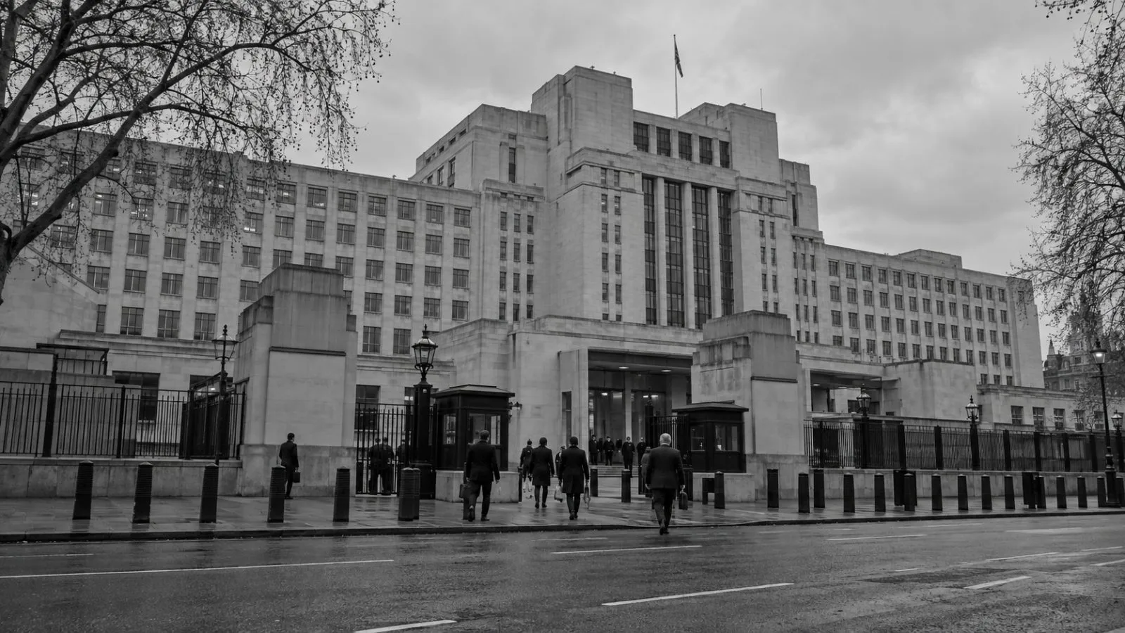 Officials pass the Ministry of Defence Main Building on Whitehall in central London. (AI-generated image / EconoTimes)