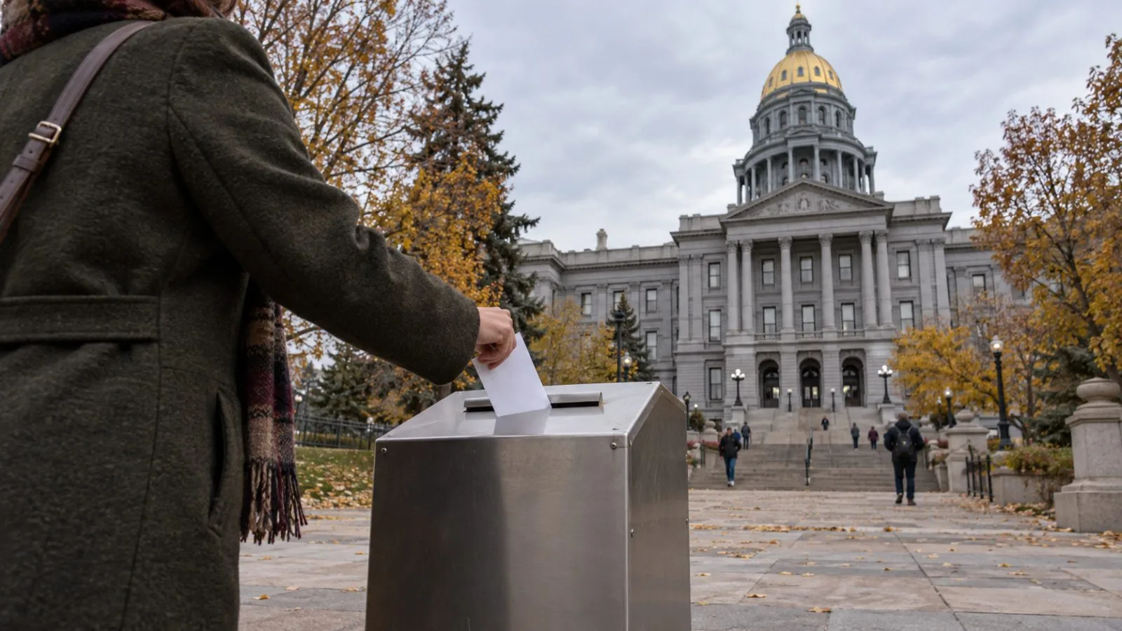 A voter drops a ballot at a voting center near the Colorado State Capitol in Denver. (AI-generated image / EconoTimes)
