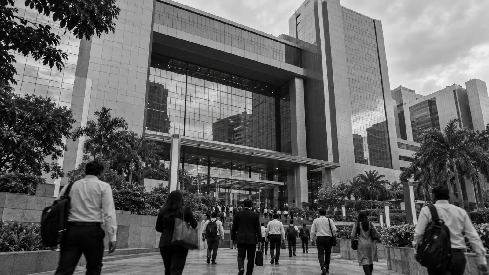 Office workers pass the glass facade of the National Stock Exchange in Mumbai’s Bandra-Kurla Complex. (AI-generated image / EconoTimes)