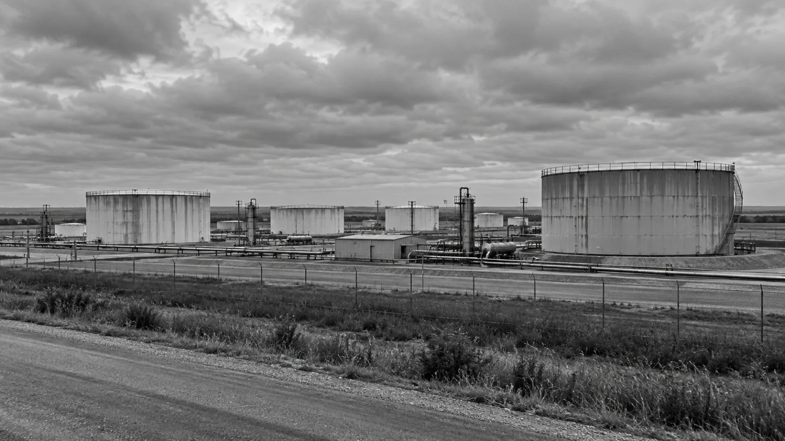 Crude oil tanks and connecting pipes stand at a storage terminal outside Cushing, Oklahoma. (AI-generated image / EconoTimes)