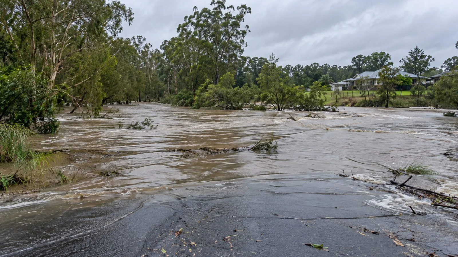 Floodwater covers a low-lying road in Caboolture, Queensland, after heavy rain. (AI-generated image / EconoTimes)