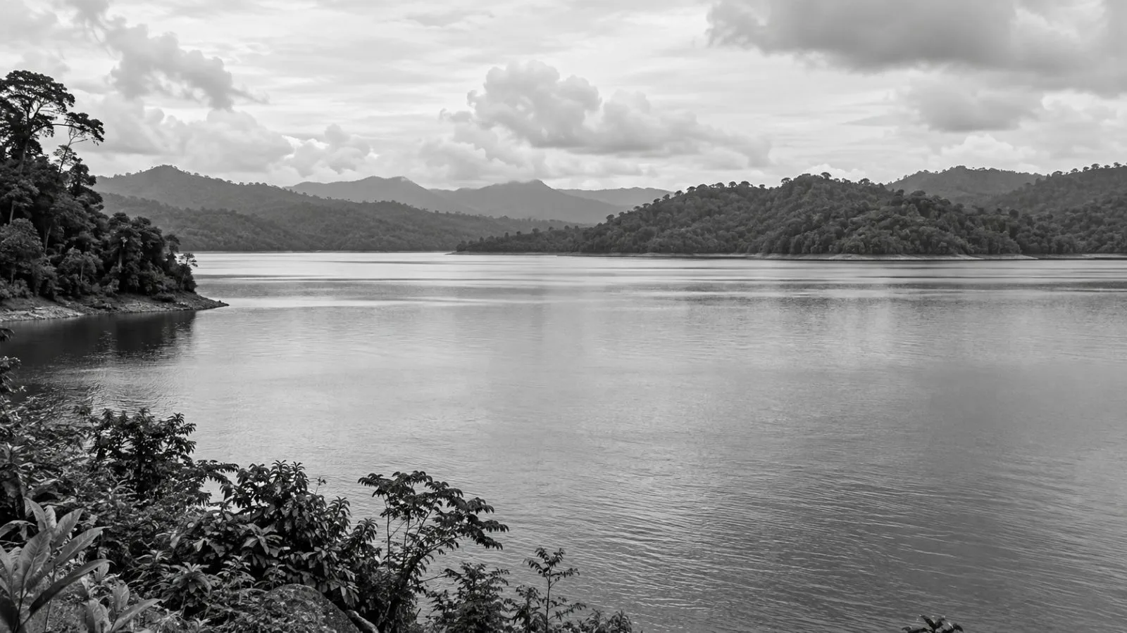 The reservoir at Chereh Dam lies beneath forested hills in Pahang, Malaysia. (AI-generated image / EconoTimes)