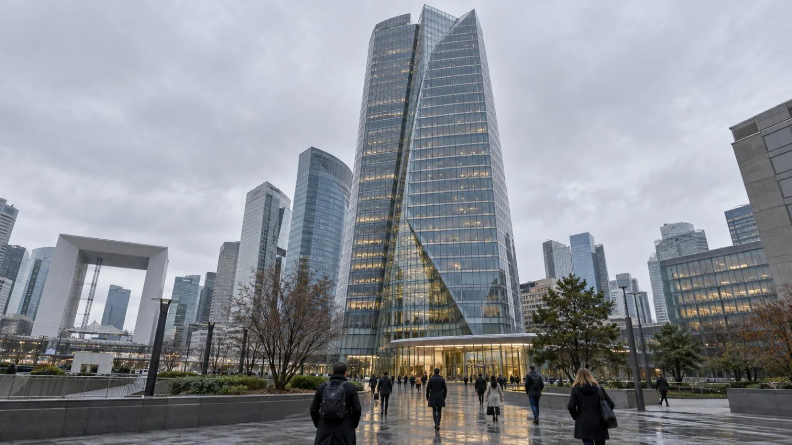 Workers enter Tour Alto in Courbevoie, France, on an overcast morning. / EconoTimes.ai