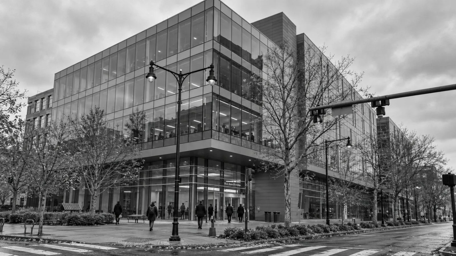 Employees enter Biogen's headquarters on Binney Street in Cambridge, Massachusetts, on an overcast morning. / EconoTimes.ai