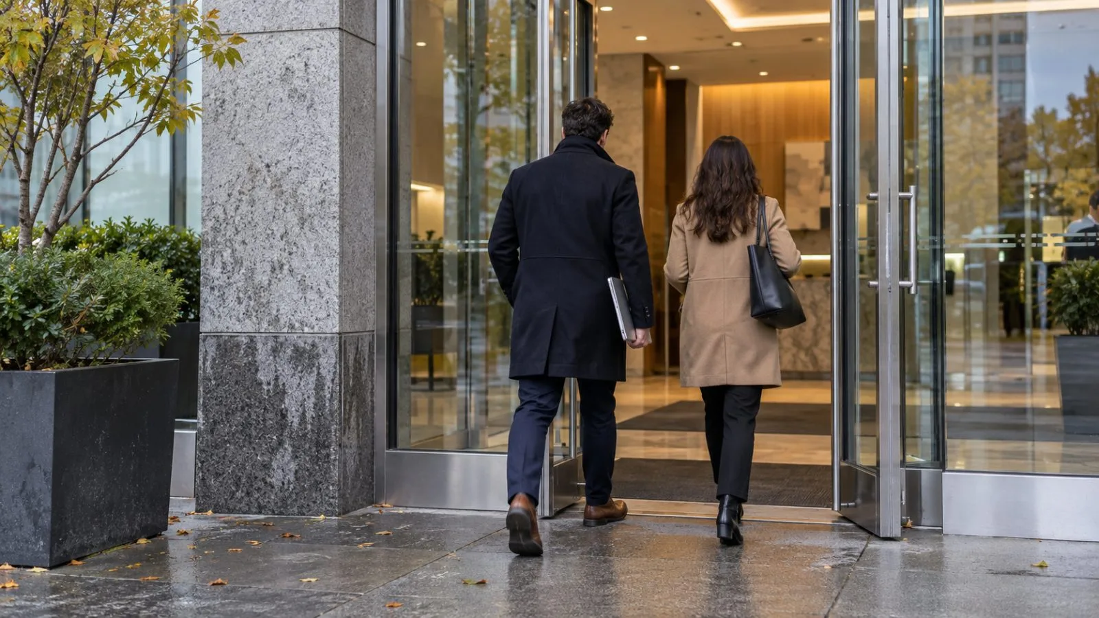 Anonymous workers carry a laptop through a downtown office building in Wilmington, Delaware. (AI-generated image / EconoTimes)