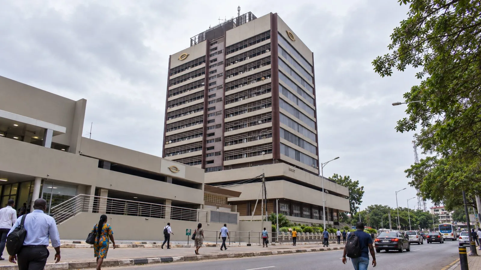 Pedestrians pass the Bank of Ghana headquarters in Accra on an overcast afternoon. / EconoTimes.ai