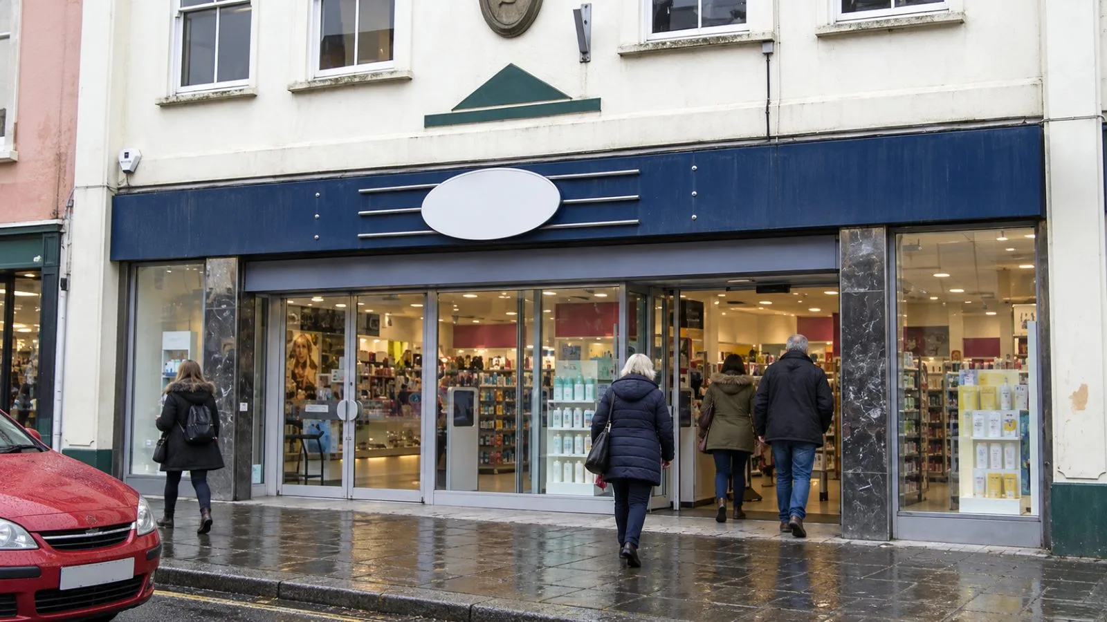 Shoppers enter a pharmacy on an overcast afternoon in Nottingham, England. / EconoTimes.ai