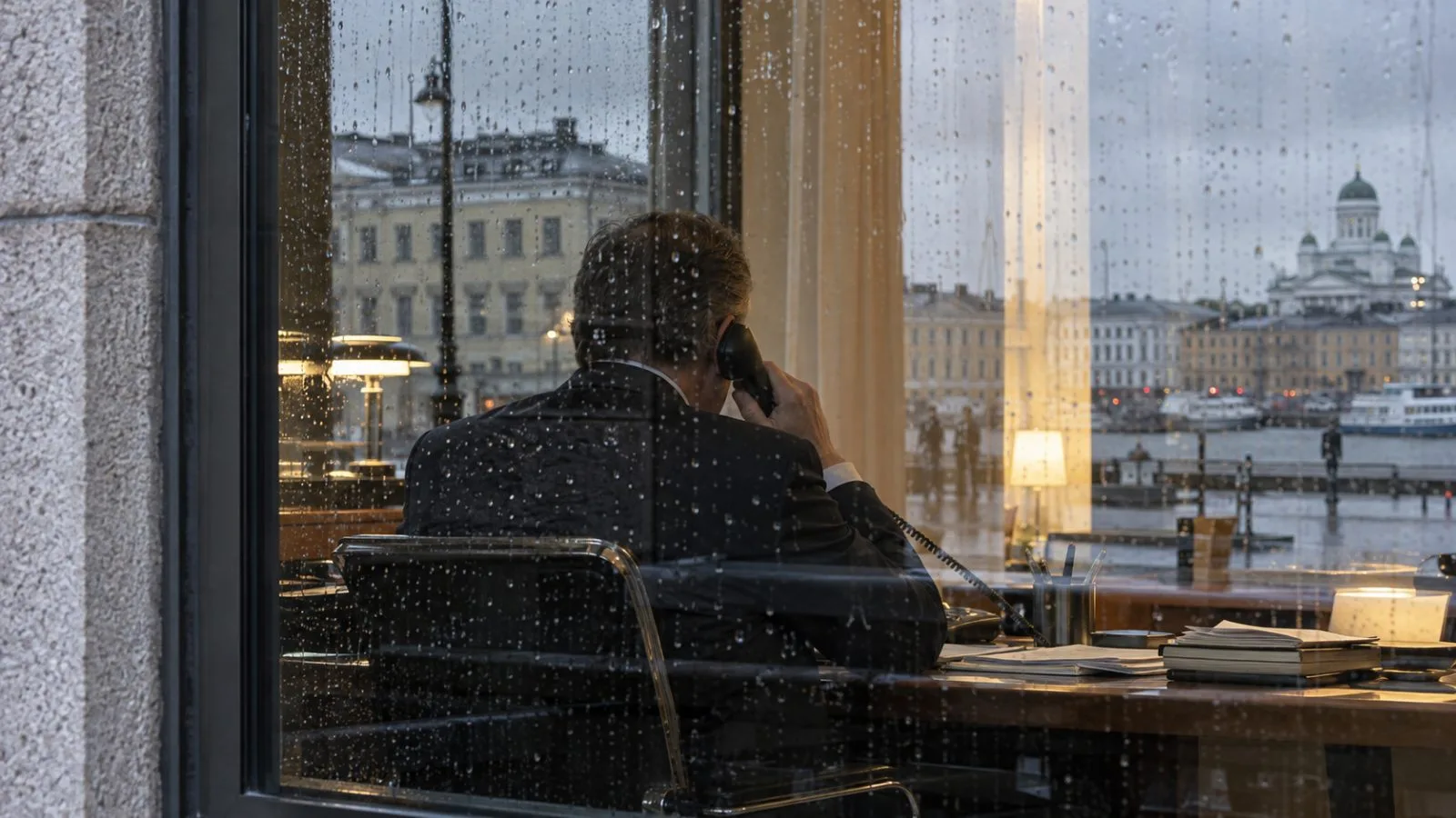 Rain beads on a Helsinki government building window as autumn light falls across the facade. (AI-generated image / EconoTimes)
