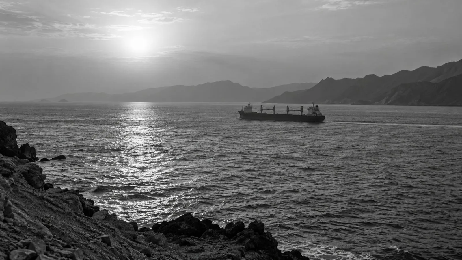 A commercial vessel crosses the Strait of Hormuz off Bandar Abbas, Iran, in late afternoon haze. (AI-generated image / EconoTimes)