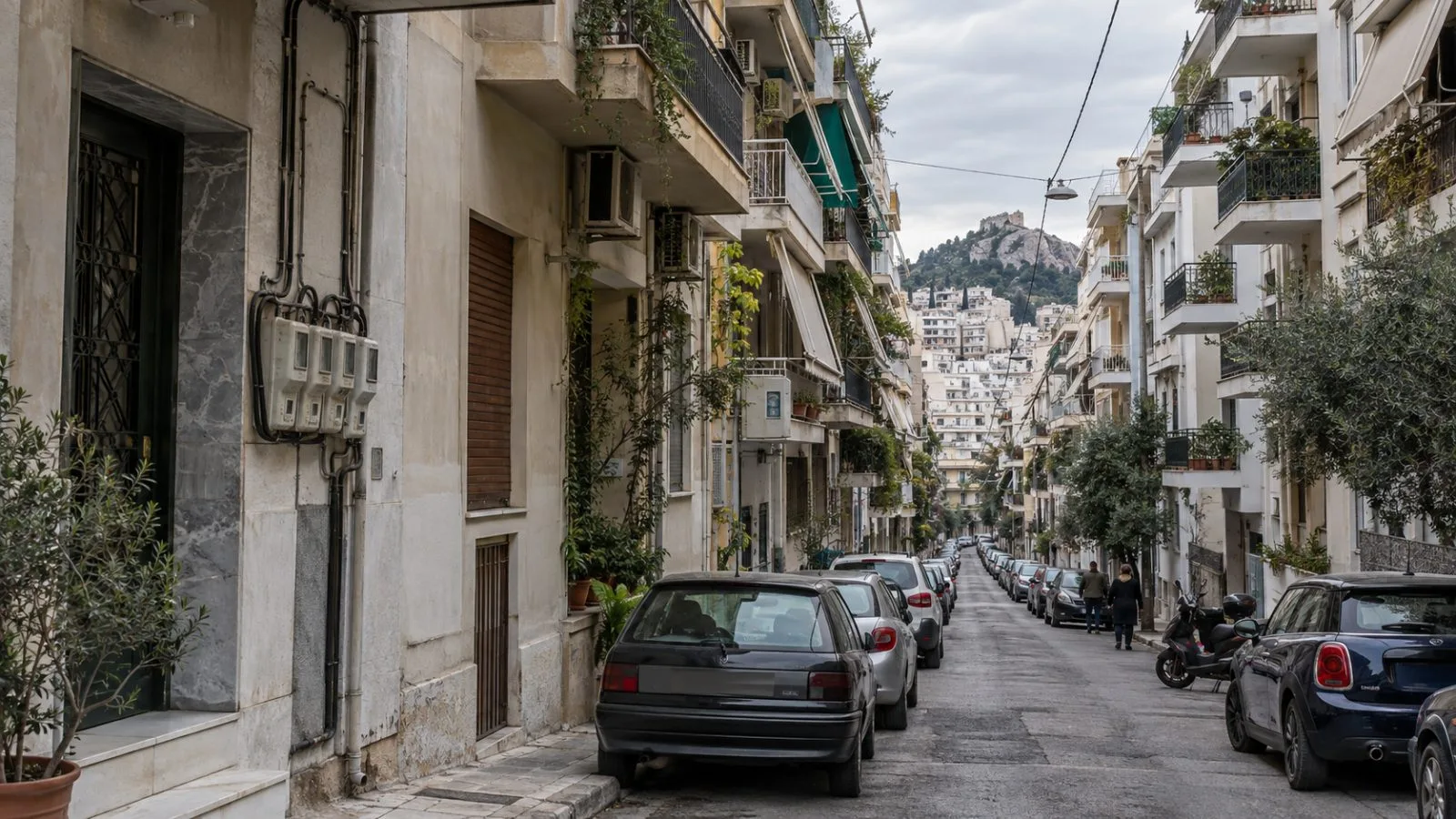 Apartment blocks line a residential street in Athens, Greece, beneath an overcast morning sky. (AI-generated image / EconoTimes)