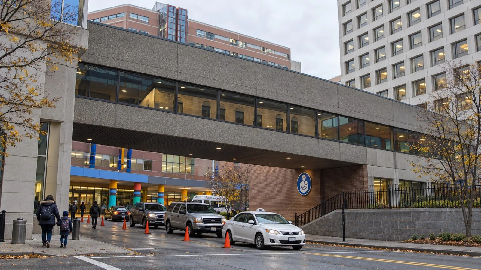A parent and child enter Boston Children’s Hospital in Boston’s Longwood Medical Area on an autumn morning. / EconoTimes.ai