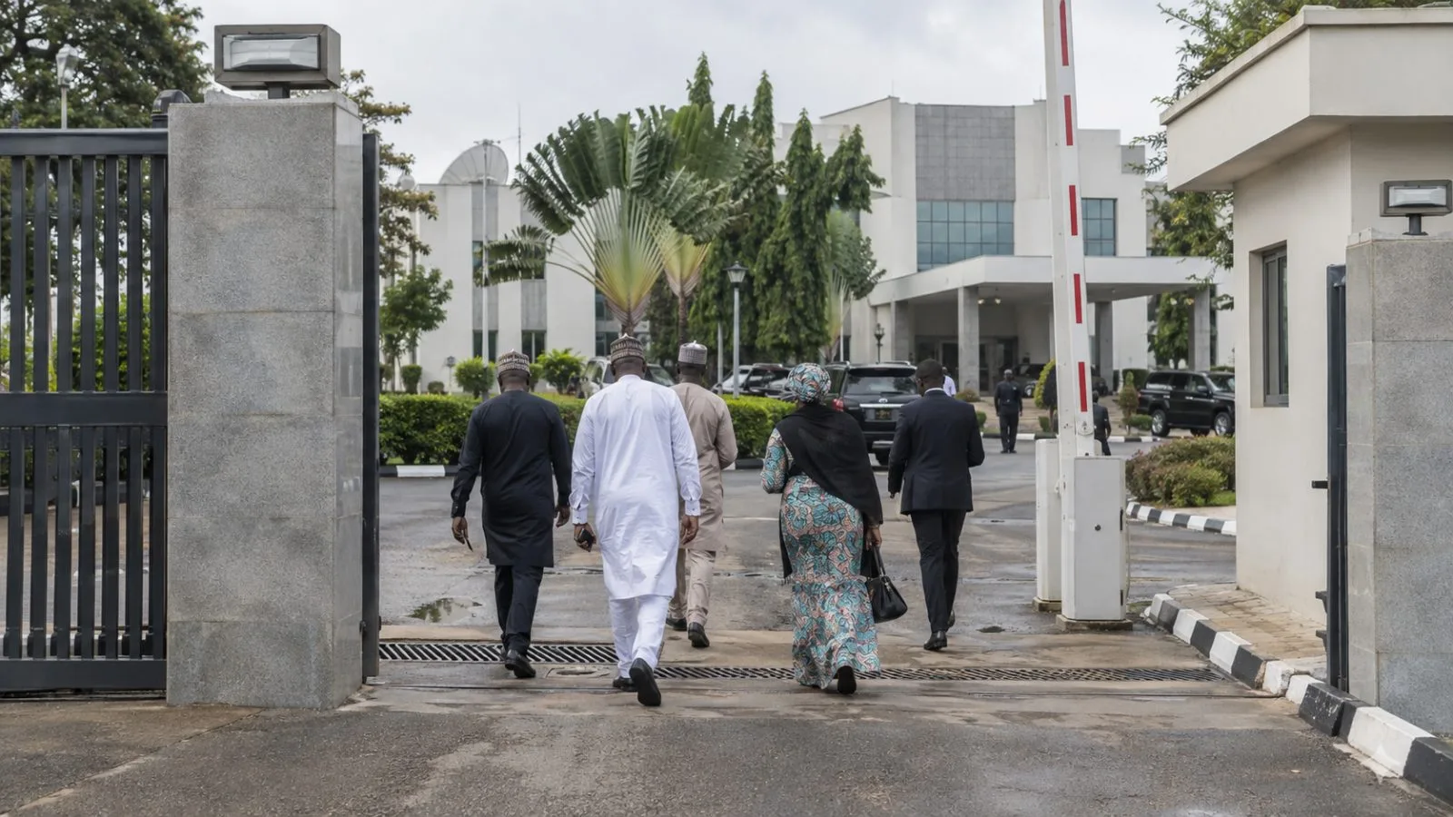 People enter the All Progressives Congress national secretariat in Abuja, Nigeria, on an overcast morning. (AI-generated image / EconoTimes)