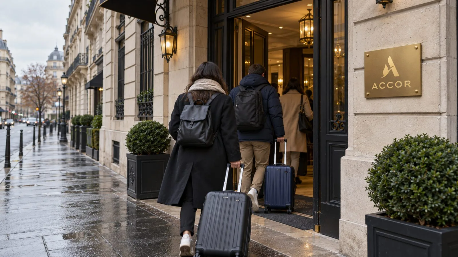 Travelers pull suitcases into a hotel on a street in central Paris, France. / EconoTimes.ai