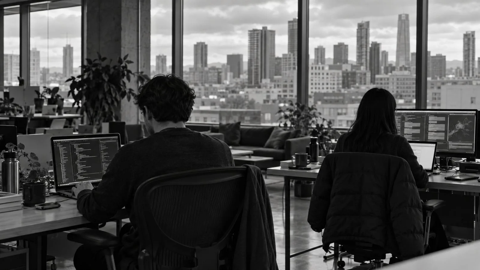 An engineer works on a laptop inside a San Francisco office. / EconoTimes.ai (mono)