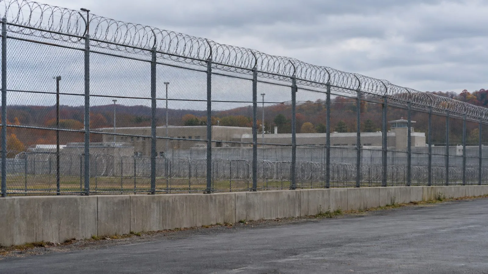 A high perimeter fence surrounds U.S. Penitentiary Allenwood in Allenwood, Pennsylvania (AI-generated image / EconoTimes)