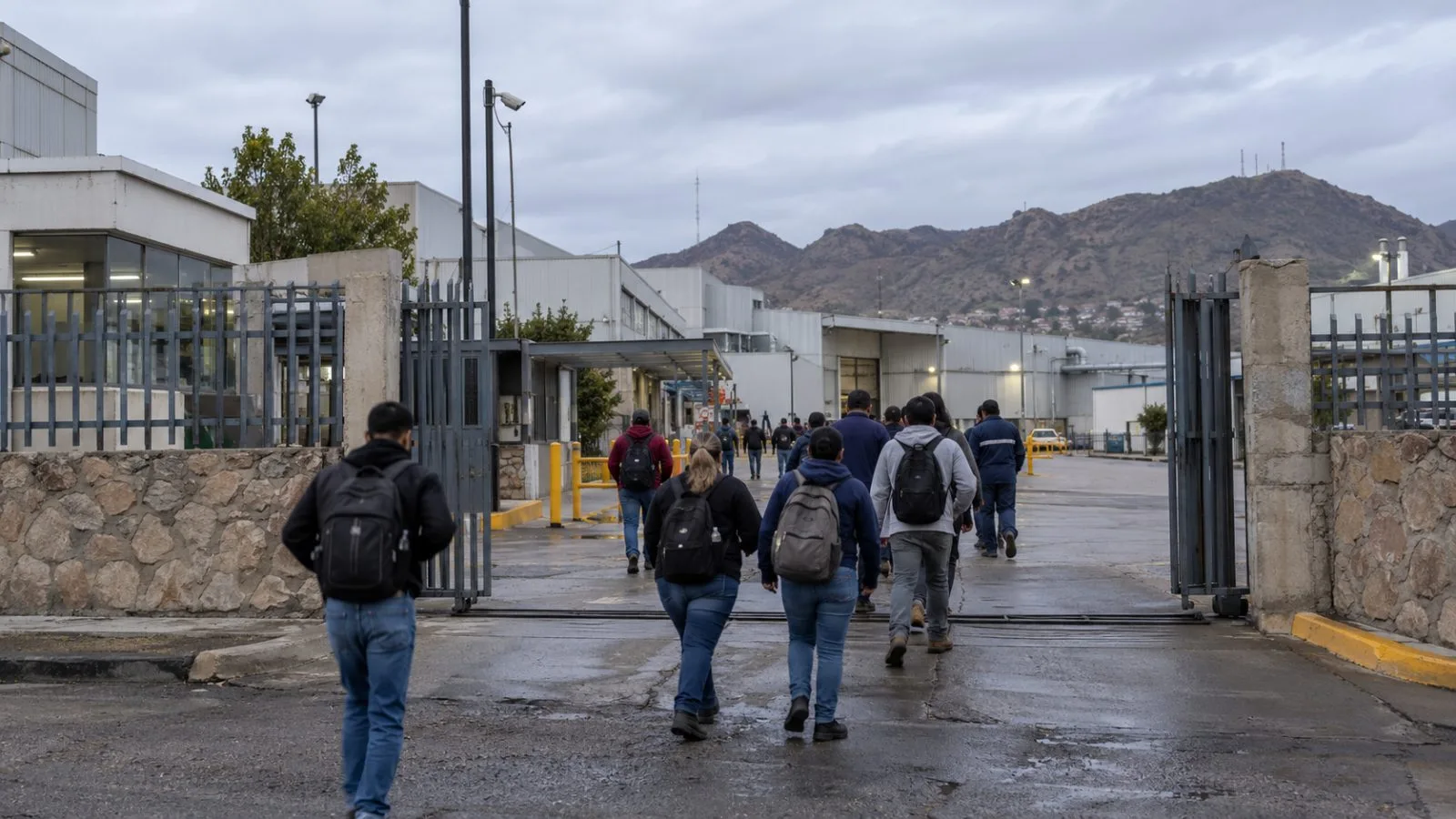 Workers enter an industrial plant in Nogales, Sonora, Mexico, during the morning shift change. (AI-generated image / EconoTimes)