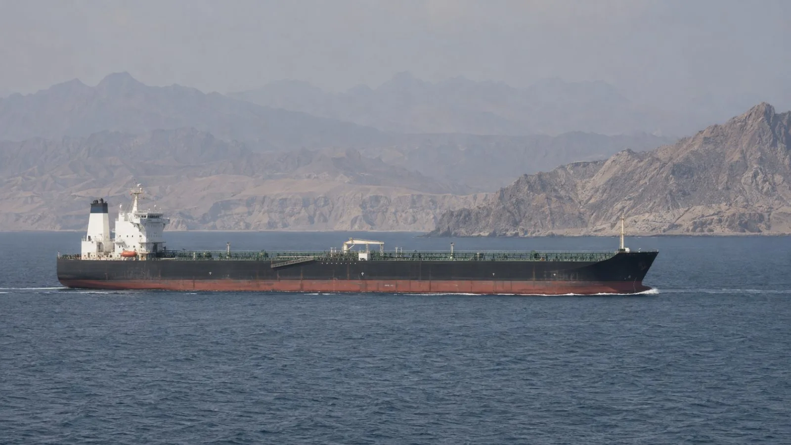 A merchant tanker passes through the Strait of Hormuz off Iran's southern coast (AI-generated image / EconoTimes)