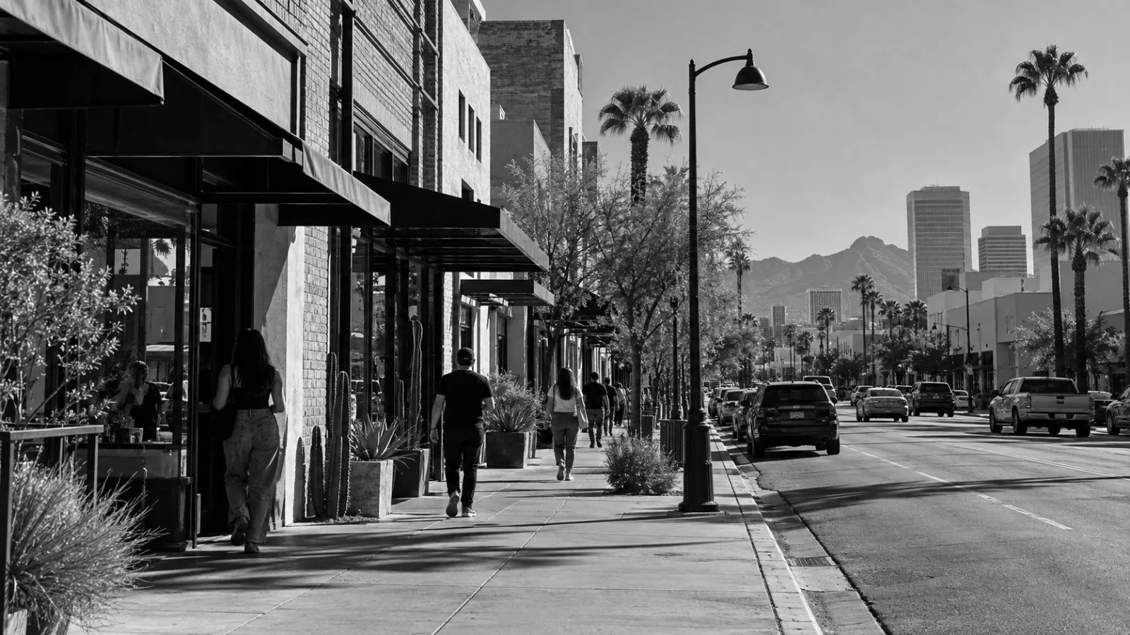 Pedestrians pass small storefronts on a sunny street in downtown Phoenix, Arizona. (AI-generated image / EconoTimes)