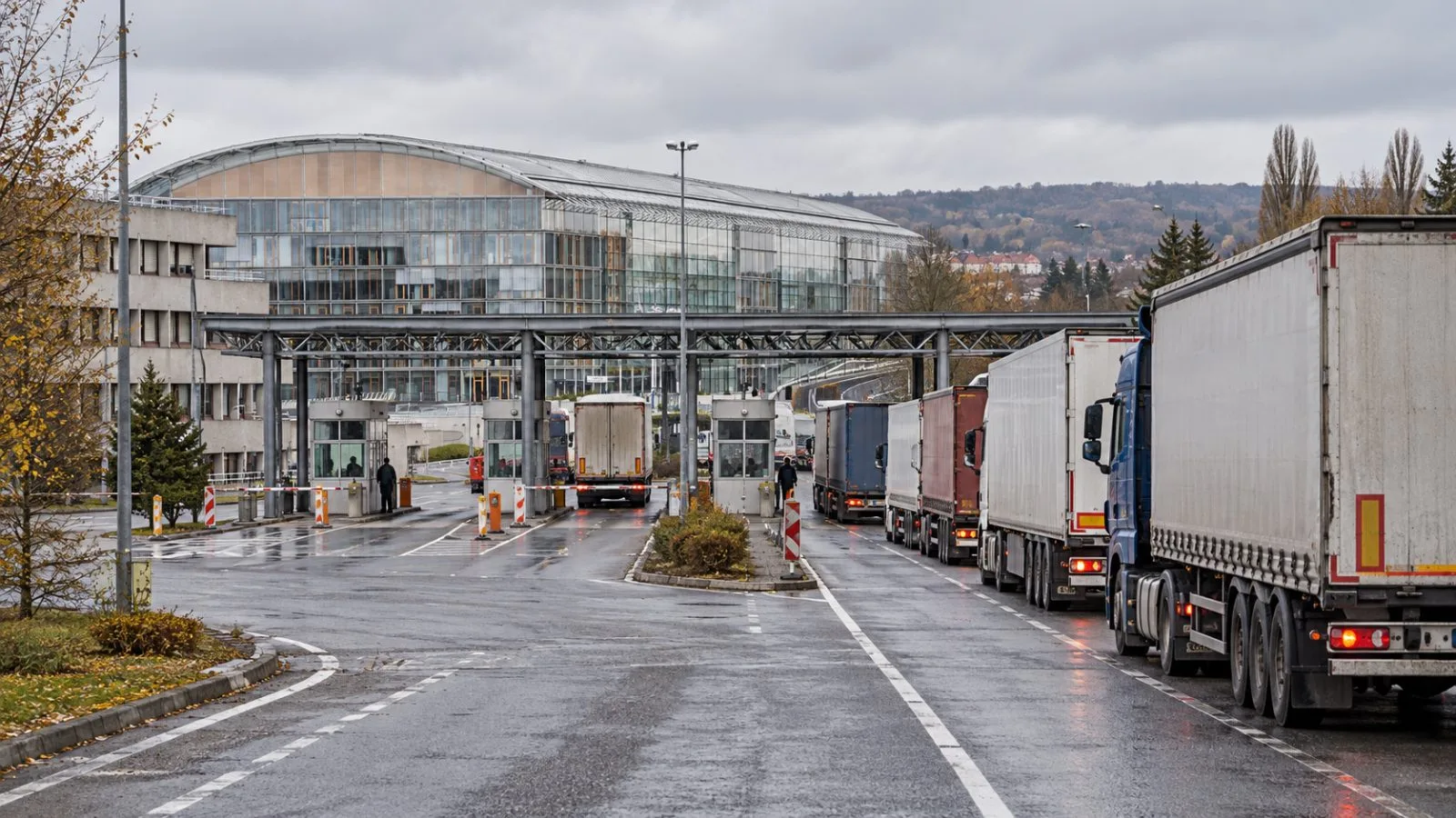 Freight trucks wait in inspection lanes at the Uzhhorod border crossing in Ukraine. / EconoTimes.ai