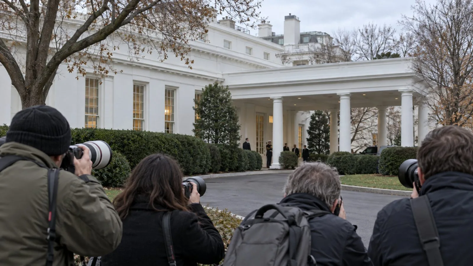 Reporters stand outside the White House West Wing in Washington. (AI-generated image / EconoTimes)