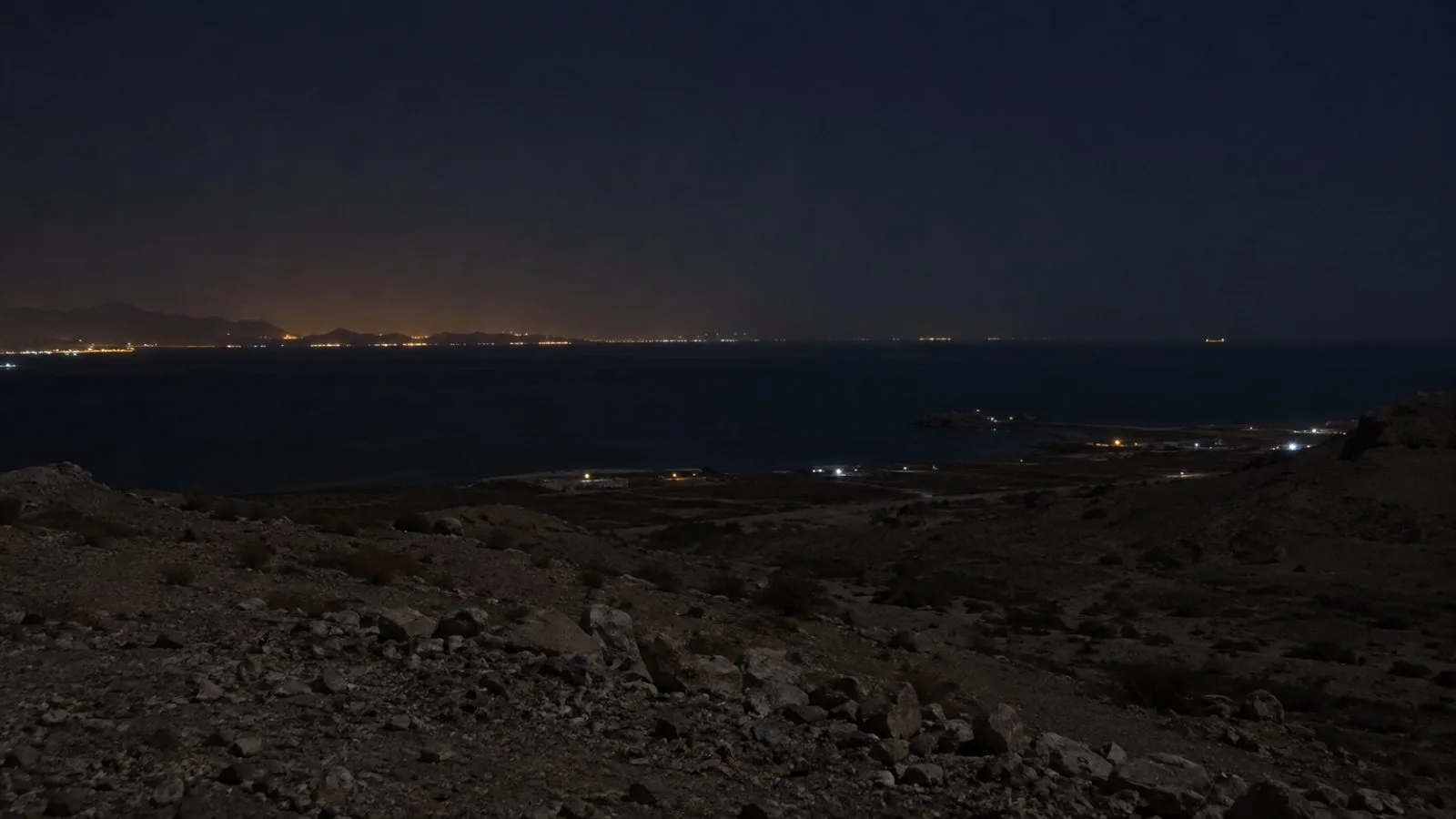 Sparse lights mark the shoreline near Sirik, Hormozgan province, along the Strait of Hormuz. (AI-generated image / EconoTimes)