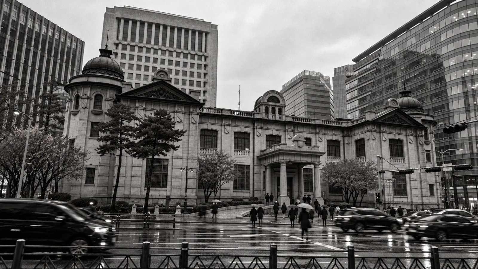 Pedestrians pass the Bank of Korea headquarters in Seoul on an overcast morning. / EconoTimes.ai