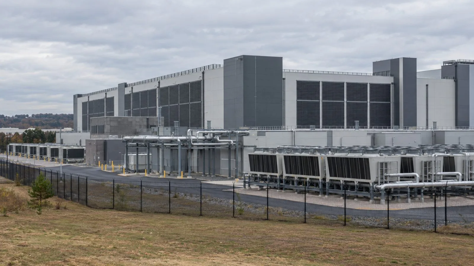 Cooling equipment stands beside a data center building in Ashburn, Virginia. (AI-generated image / EconoTimes)