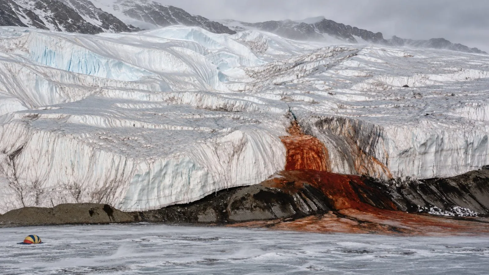 Red iron-rich brine stains the ice beside Blood Falls on Taylor Glacier, Antarctica. / EconoTimes.ai